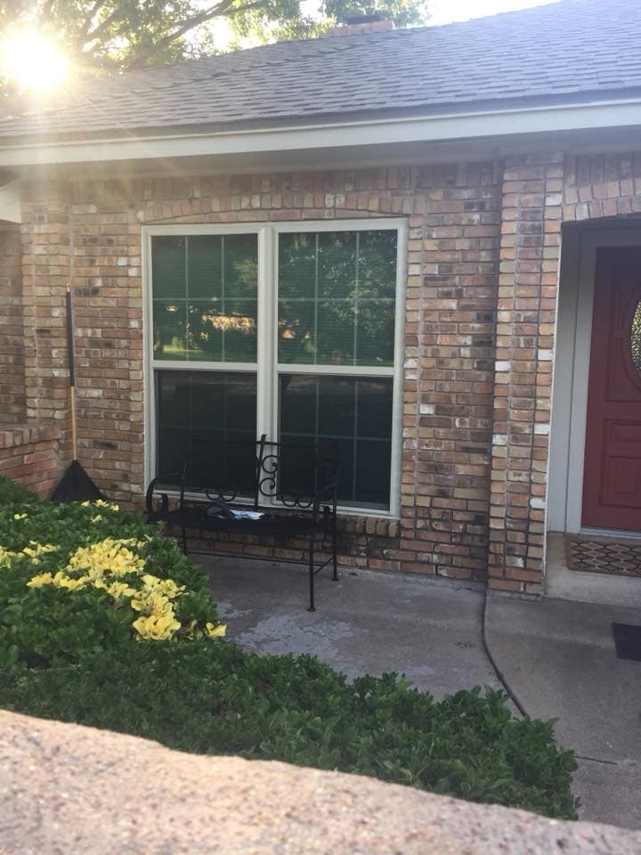 Red entry door and windows on a brick home