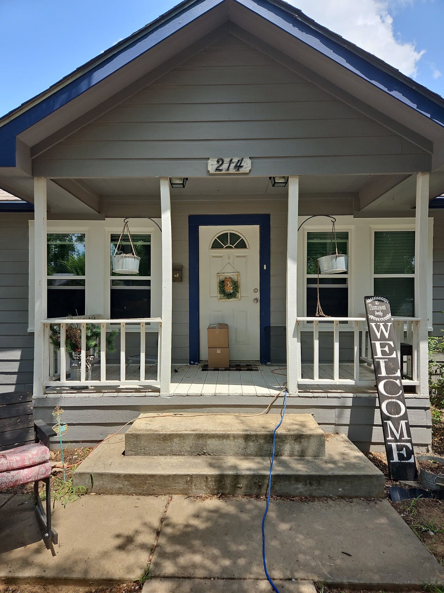 White front door framed by a shaded porch and matching windows